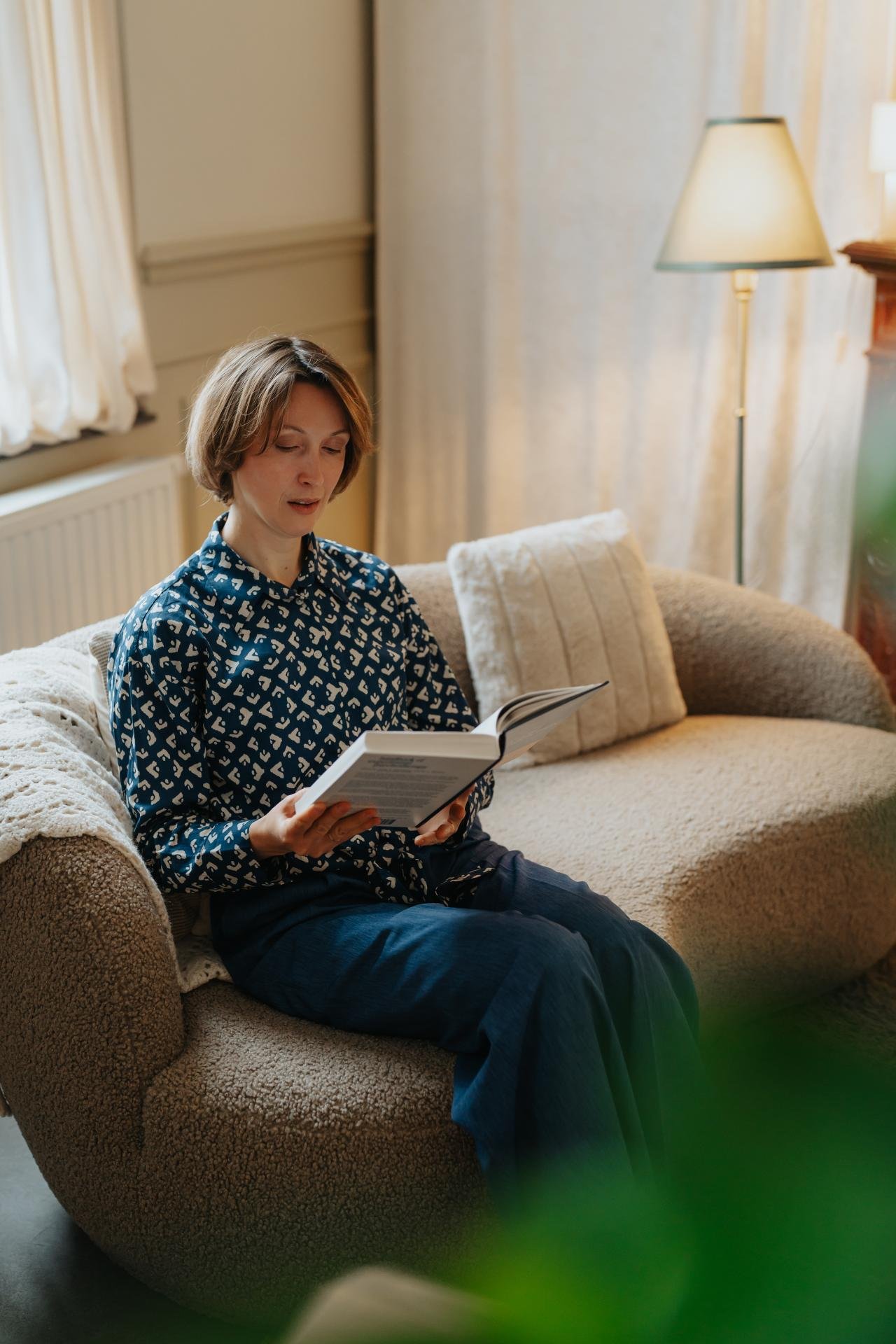 Vrouw leest een boek op een comfortabele design sofa